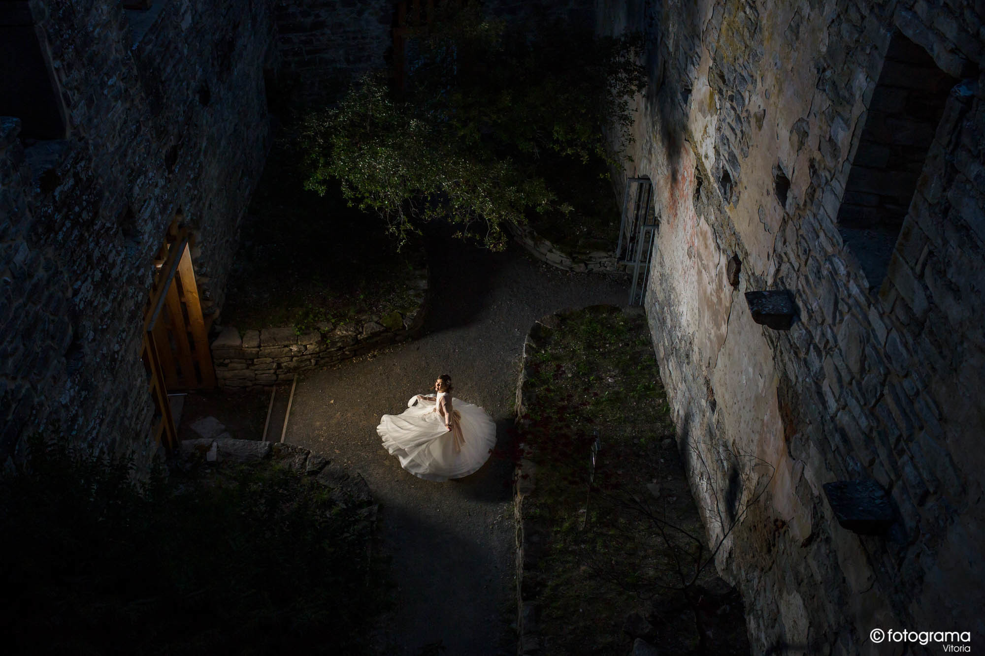 niña de comunión girando con su vestido en un castillo de noche