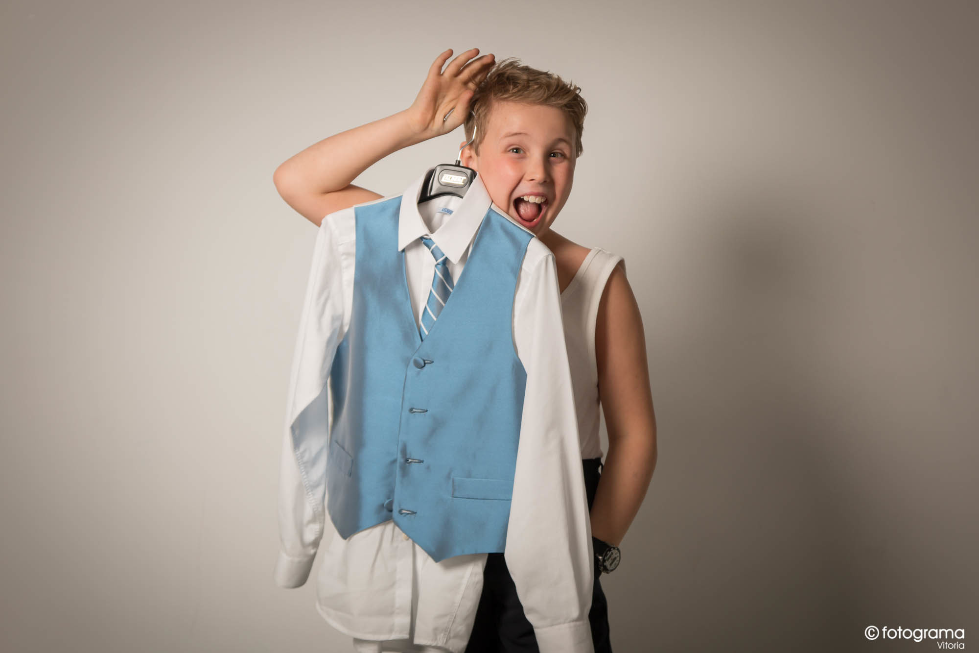 niño muestra su traje de comunión