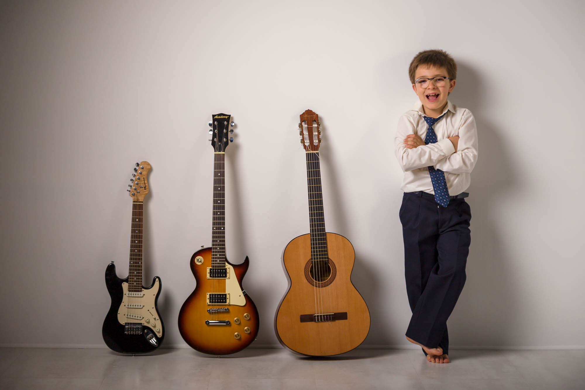 niño de comunion divertido con guitarras